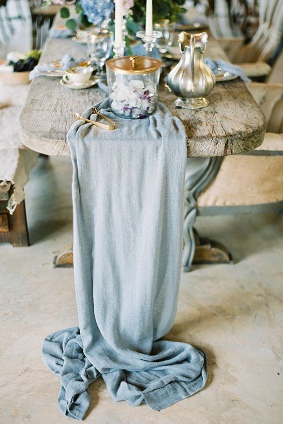 a chic light blue fabric table runner, matching blooms and napkins are ideal to create a coastal wedding table
