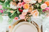 a colorful spring wedding centerpiece in light pink, blush, peachy and with much textural greenery