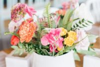 a colorful spring wedding centerpiece in pink, orange, yellow and with some greenery