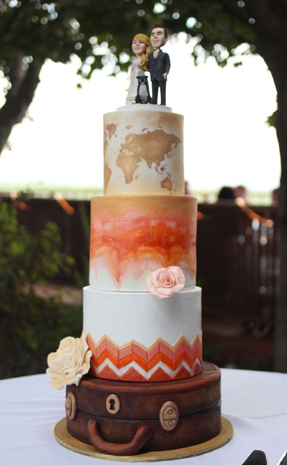 a colorful wedding cake with a map, a watercolor and bright chevron tier, pastel blooms and fun cake toppers