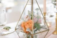 a creative terrarium with light mint greenery and coral blooms is a pretty and chic wedding centerpiece to rock