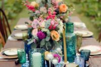 a dip dyed blue fabric table runner, blue candle holders and glasses for a boho wedding table