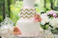 a glam white wedding cake decorated with pink ribbon, with gold chevron tiers, pink sugar blooms is a lovely idea for a refined vintage-inspired wedding