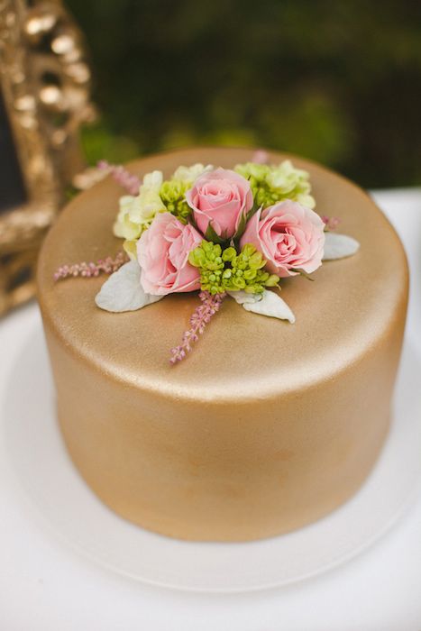 a gold wedding cake with pale greenery, pink and green blooms is great for a summer wedding