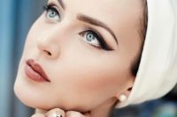a gorgeous retro wedding makeup with cat eyes, a matte dusty rose lup annd a perfect skin tone
