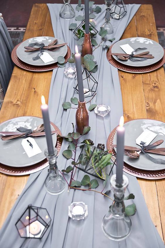 a grey fabric table runner, grey candles, tealights in terrariums and eucalyptus for a refined tablescape