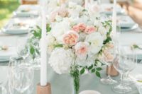 a mint tablecloth, white and coral blooms and white and coral candles for a tender spring and summer wedding