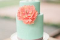 a mint wedding cake with a coral sugar bloom and edible origami is a cool idea for a bright wedding