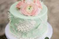 a mint wedding cake with white detailing and fresh coral blooms on top is a gorgeous idea for a wedding