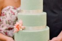 a mint wedding cake with white ribbons and coral blooms is a cool dessert for a wedding with a color scheme
