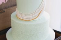 a patterned mint wedding cake with edible beads and a flower is a cool and bright idea for a wedding