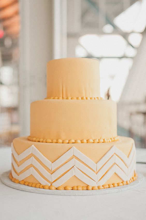 a peachy round wedding cake with a chevron tier and sugar beads is a bold idea for a spring or summer wedding