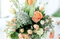 a pretty wedding centerpiece of coral and cremay blooms and lots of textural greenery for a texture