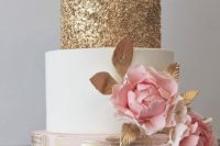 a romantic wedding cake with a gold, white and blush tier, pink sugar blooms with leaves