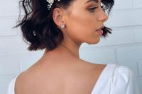 a short wavy bob with a pearl and rhinestone hairpiece is a refined and bold idea for a modern chic look