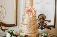 a sophisticated gold patterned wedding cake with a blush sugar bloom is a very spectacular and chic idea