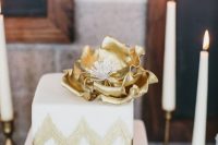 a square gold and white chevron wedding cake topped with an oversized gold flower is a lovely idea for a mid-century modern wedding