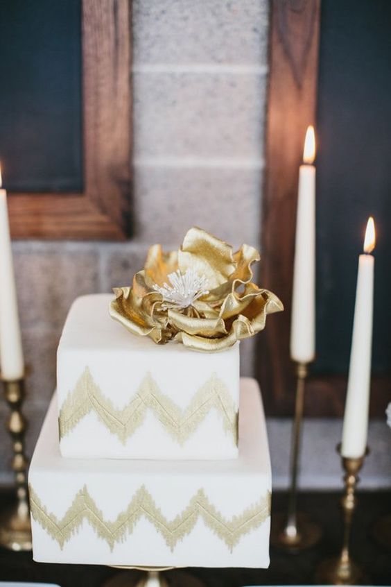 a square gold and white chevron wedding cake topped with an oversized gold flower is a lovely idea for a mid-century modern wedding