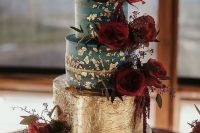 a teal and gold leaf wedding cake with burgundy blooms and a calligraphy topper for a super bold wedding