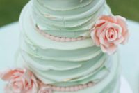 a textural mint wedding cake with a gold edge and pink sugar blooms looks very pretty and delicious