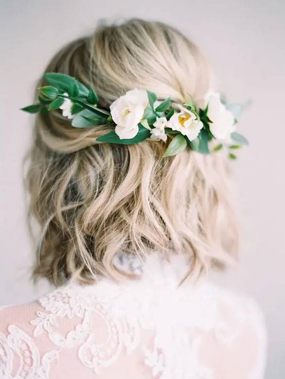 a wavy hairstyle with fresh white blooms and greenery on the back for a romantic bride