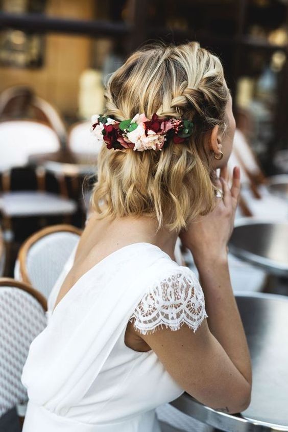 a wavy half updo with braids and a bit of blooms and greenery added to the hairstyle is a chic solution to rock