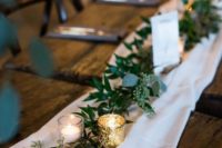 an airy white fabric table runner paired with a eucalyptus one and votives is a timeless idea to rock
