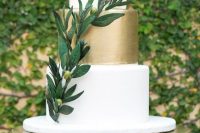 an elegant white and gold wedding cake with an olive branch is very chic and very modern