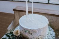 forget usual cake toppers for go for tall and thin candles, greenery and white blooms to make your wedding cake very chic and refined