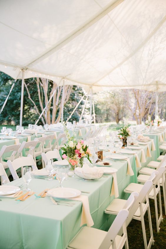 mint tablecloths and coral, pink and white floral wedding centerpieces to set up the tables