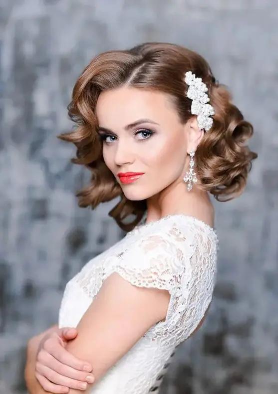 short curly bridal hair with a side pearl hairpiece to make a glam and girlish accent