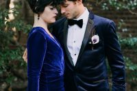 a Goth-inspired groom’s look with a midnight blue velvet tux with black lapels, a black bow tie and pants and a calla boutonniere
