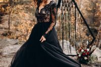 a beautiful boho moody black A-line wedding dress with a black lace bodice and a layered plain skirt plus a black hat and a black lip