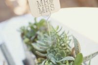 a beautiful wedding centerpiece with succulents and greenery and a topper is a stylish modern wedding decor idea