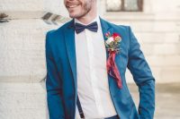 a bold blue suit, a black bow tie, black suspenders and a colorful boutonniere for a bright feel