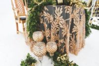 a botanical print tablecloth, a greenery table runner, candles, elegant candleholders for a snowy wedding