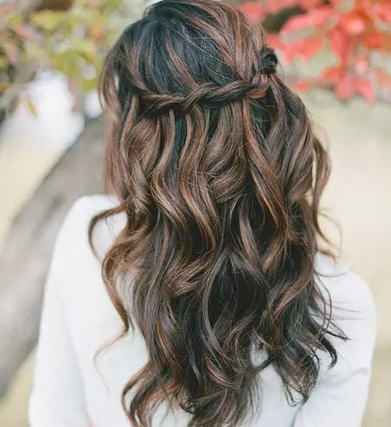 a braided half updo with waves looks spectacular thanks to the caramel balayage on black