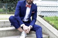 a bright blue wedding suit, no socks, white sneakers and a coral printed bow tie
