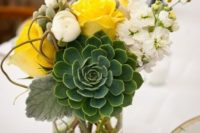 a bright wedding centerpiece with a large succulent, white and yellow blooms and berries