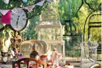 a brigth Mad Hatter setting with colorful buntings, clocks, lots of cages and bright porcelain