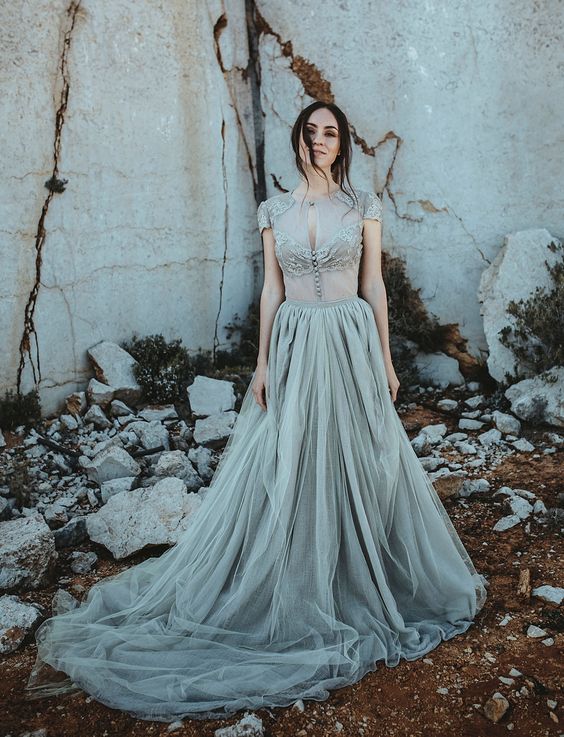 a chic and beautiful grey wedding dress with a sheer bodice with lace appliques and a tulle skirt with a train