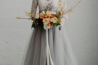 a chic bridal look with a grey tulle skirt and a white lace top with long sleeves for a modern romantic bride