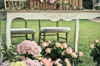 a crate with blooms, letters, a crate with blooms and letters on the table to accent a garden sweetheart table