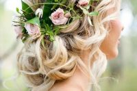 a crown of roses sits a top of a curled bun, with pieces pulled out here and there for an ethereal do