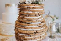 a delicious wedding cake made of large cookies and cream plus some blooms on top is totally non-traditional