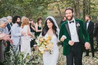 a fall groom’s look with black pants, a white shirt, an emerald velvet tux with black lapels and black shoes