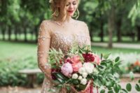 a gold embellished wedding dress paired with a lush wedding bouquet with pink, burgundy, blush blooms and greenery