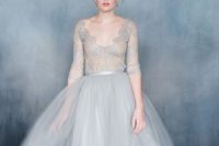 a gorgeous wedding ballgown in dove grey with a lace bodice with long sleeves and a full skirt for a refined look