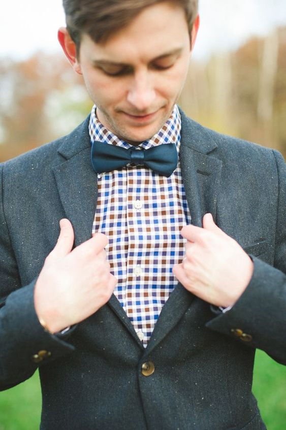 a graphite grey suit, a colorful plaid shirt, a navy bow tie for a bold fall groom's look