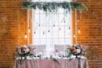 a greenery and bulb installation, lush pastel florals and marquee monograms to highlight the sweetheart table